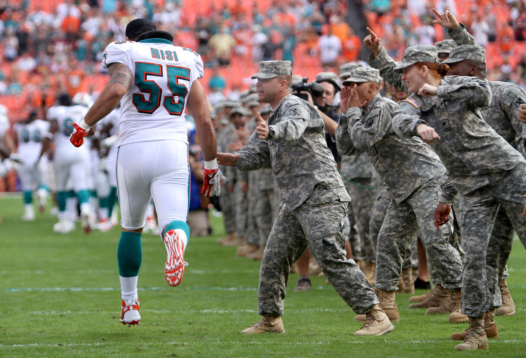 Miami Dolphins outside linebacker Koa Misi (55) is greeted by U.S. Army soldiers